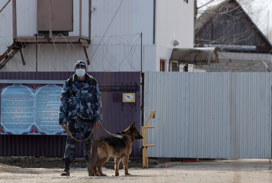 Pracownik Federalnej Służby Więziennej Rosji stoi z psem służbowym przed Kolonią Karną nr 2 w mieście Pokrov, około 85 km na wschód od Moskwy, gdzie odbywa karę skazany działacz opozycji Aleksiej Nawalny /TASS /PAP/ITAR-TASS