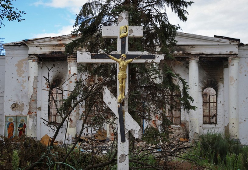 Prawosławny krzyż stojący przed zniszczonym budynkiem w Popasnej /ALEXANDER ERMOCHENKO/Reuters /© 2022 Reuters