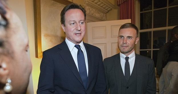 Premier Wielkiej Brytanii David Cameron (L) i piosenkarz Gary Barlow (P) /AFP