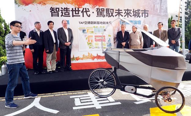 Premierowi Tajwanu Mao Chi-kuo (Ś, różowa koszula) elektryczny tricykl przypadł do gustu /EPA