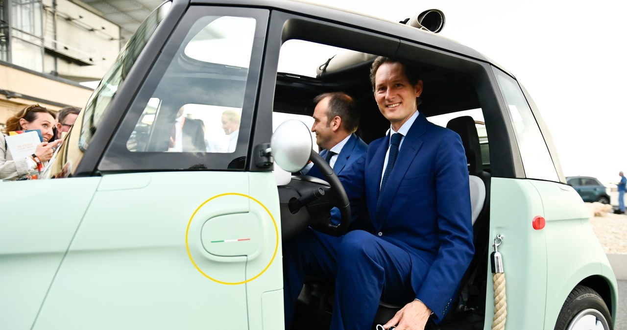 Prezes Fiata John Elkann podczas prezentacji Fiata Topolino w 2023 roku. Na błotniku dostrzeżemy niewielką włoską flagę /Getty Images