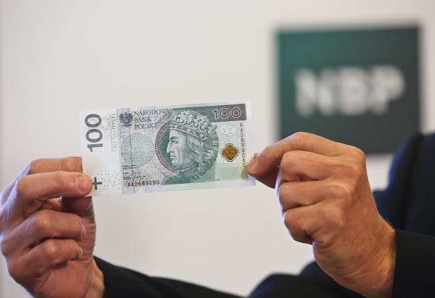 Prezes Narodowego Banku Polskiego Marek Belka prezentuje banknot stuzłotowy /PAP