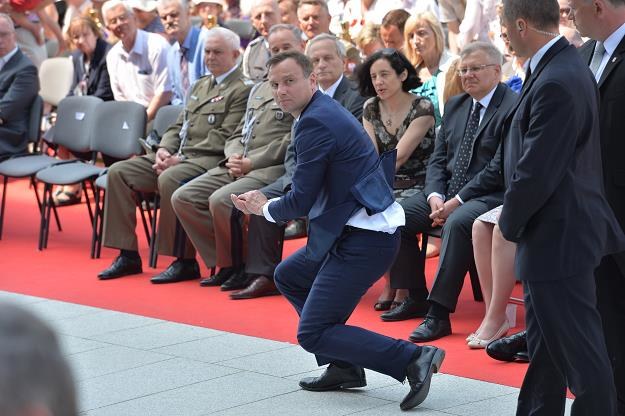 Prezydent elekt Andrzej Duda (C) podnosi hostię, którą porwał wiatr podczas mszy  w Wilanowie /PAP