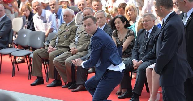 Prezydent elekt Andrzej Duda (C) podnosi hostię, którą porwał wiatr podczas mszy  w Wilanowie /PAP