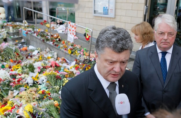 Prezydent Ukrainy Petro Poroshenko i ambasador Holandii w Kijowie Kees Klompenhouwer. W tle: kwiaty układane przed ambasadą Holandii w hołdzie ofiarom katastrofy Boeinga 777 /SERGEY DOLZHENKO /PAP/EPA