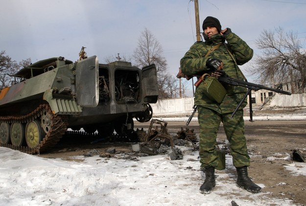 Prorosyjski separatysta przy zniszczonym ukraińskim transporterze opancerzonym koło Debalcewe /ALEXANDER ERMOCHENKO /PAP/EPA