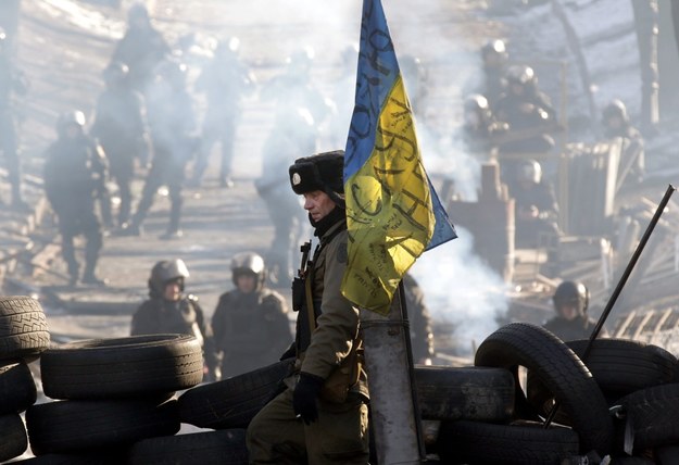 Protestujący na barykadzie w Kijowie. W tle milicjanci /MAXIM SHIPENKOV    /PAP/EPA