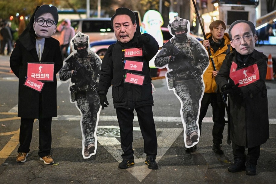 Protestujący w maskach z wizerunkami szefa Partii Władzy Ludu Han Dong-hoona, prezydenta Korei Południowej Yoon Suk Yeola i przywódcy Partii Władzy Ludu Choo Kyung-ho domagają się obalenia prezydenta Korei Południowej Yoon Suk Yeola przed Zgromadzeniem Narodowym w Seulu, 6 grudnia 2024