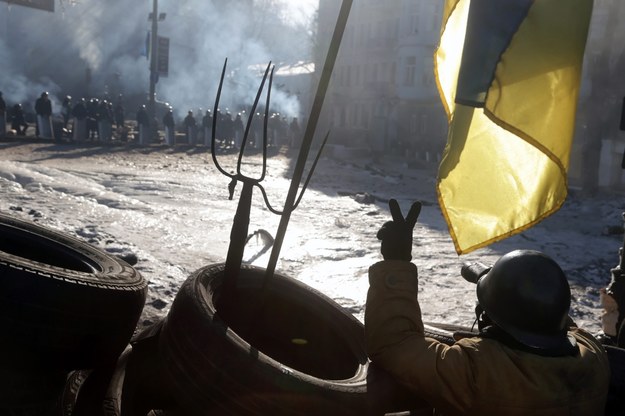 Protestujący z Majdanu Niepodległości pokazuje milicjantom znak zwycięstwa /MAXIM SHIPENKOV    /PAP/EPA
