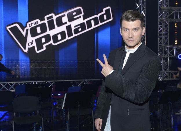 Prowadzący program Tomasz Kammel na tle loga "The Voice of Poland" /AKPA