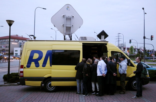 Przechodnie oglądają transmisję debaty w wozie transmisyjnym radia RMF FM, ustawionym przed siedzibą TVN w Warszawie /PAP/Paweł Supernak /PAP
