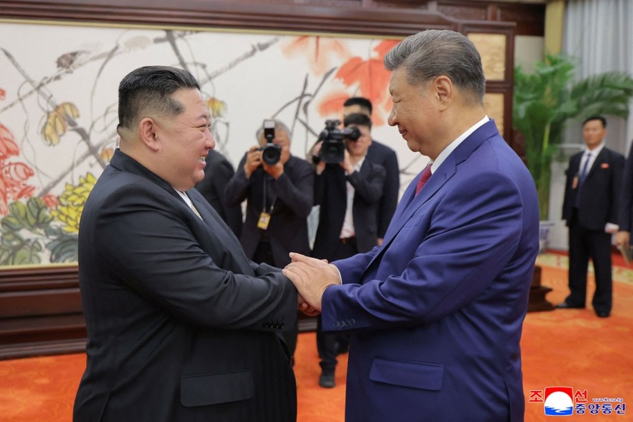 Przywódca Korei Północnej Kim Dzong Un (z lewej) ściska dłoń prezydentowi Chin Xi Jinpingowi w Pekinie /STR/AFP/East News /East News