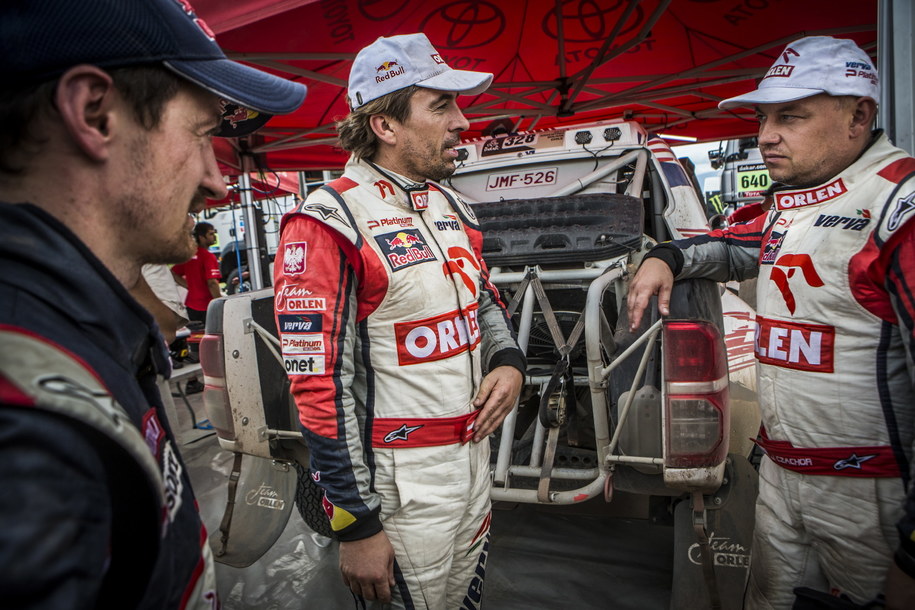 Rajdowcy Marek DÄbrowski, Jacek Czachor i Adam Małysz rozmawiajÄ na biwaku podczas Rajdu Dakar /Orlen Team/Marcin Kin /PAP