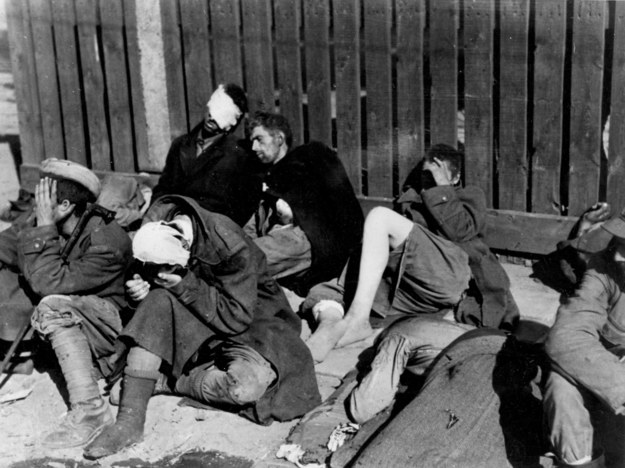 Ranni powstańcy odpoczywają przy płocie na Krakowskim Przedmieściu. Wrzesień 1944 roku. /CTK /PAP