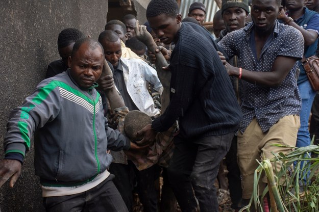 Rescue workers carry a survivor from a landslide in Kampala /Isaac Kasamani /PAP/EPA