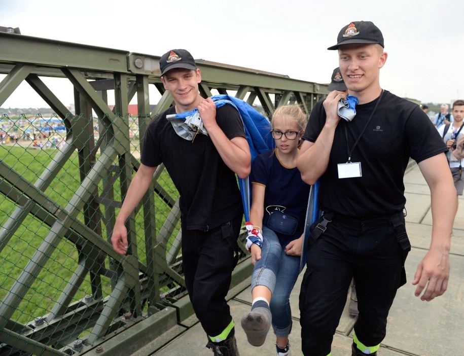 Ratownicy pomagają kontuzjowanej uczestniczce, opuścić teren Campusu Misericordiae w Brzegach /Darek Delmanowicz /PAP