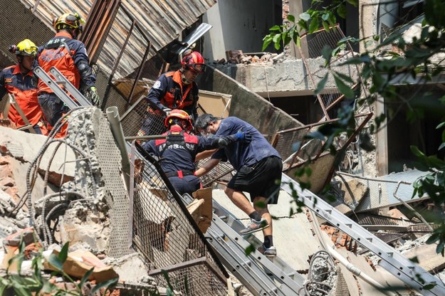 Ratownicy pomagają poszkodowanym wydostać się ze zniszczonych budynków /AFP /East News