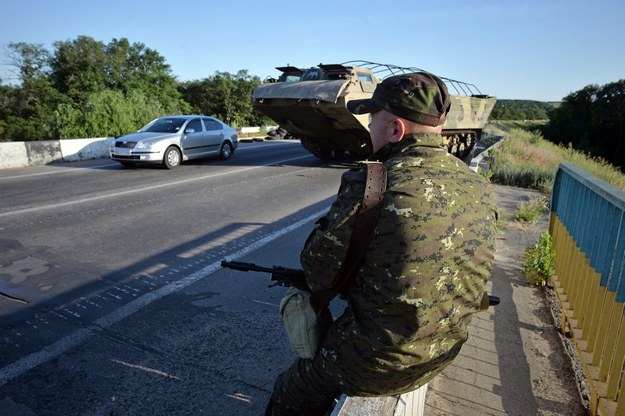 Rebeliant w punkcie kontrolnym w okolicach Ługańska, w tle transporter PTS-2 /VALENTINA SVISTUNOVA /PAP/EPA