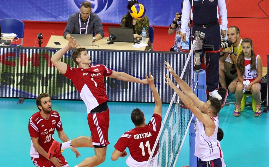 Reprezentant Polski Piotr Nowakowski  atakuje piłkę wystawiona przez Fabiana Drzyzgę, którą blokuje Russel Holmes z reprezentacji USA podczas meczu Ligi Światowej siatkarzy, Polska - USA, rozegranego w Tauron Arenie Kraków 4 lipca /Stanisław Rozpędzik /PAP