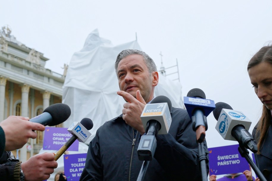 Robert Biedroń i Sylwia Spurek podczas poświęconej pedofilii w Kościele konferencji prasowej przed sanktuarium w Licheniu. Za nimi: zasłonięty wspólny pomnik oskarżonego o pedofilię budowniczego i kustosza sanktuarium ks. Eugeniusza M. i papieża Jana Pawła II
