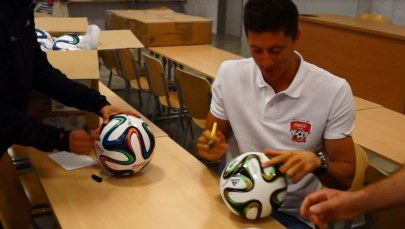 Robert Lewandowski podpisuje oficjalne piłki meczowe BRAZUCA