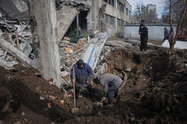 Robotnicy naprawiają uszkodzony rurociąg obok zniszczonego budynku w wyniku ostrzału w Charkowie /VASILIY ZHLOBSKY /PAP/EPA