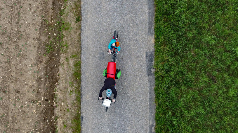 Rower dziecka holowany przez rodzica, zdjęcie autorstwa Kuby Ruty zrobione na Gościńcu Mirowskim, Szlak Orlich Gniazd w trakcie rowerowego wyjazdu z dziećmi /dzieciakiwplecaki.pl /archiwum prywatne