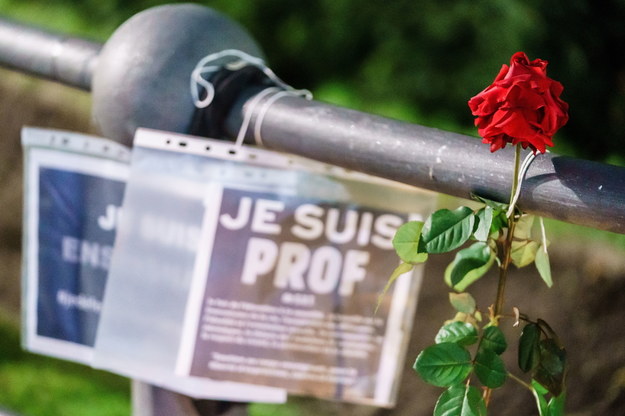 Róża i wydruk z napisem "Jestem nauczycielem" w miejscu, gdzie oddawano hołd zabitemu nauczycielowi /Clemens Bilan /PAP/EPA