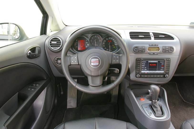 Seat Leon II: Sportowa pozycja za kierownicą. Dobra jakość wykończenia, ale materiały – przeciętne. Na konsoli opcjonalny duży ekran multimedialny – ożywia nieco tę dużą połać plastiku. /Motor