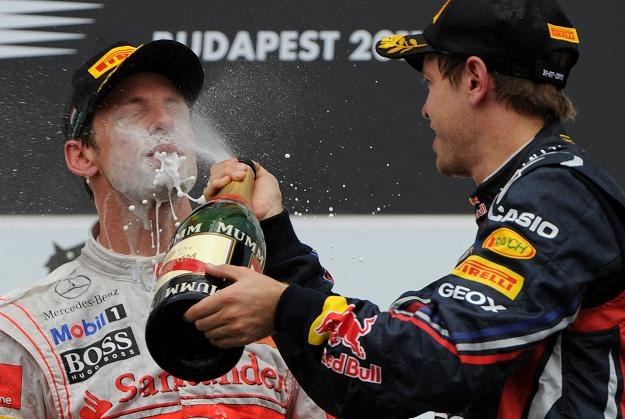 Sebastian Vettel oblewa szampanem Jensona Buttona /AFP