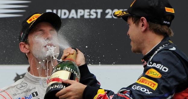 Sebastian Vettel oblewa szampanem Jensona Buttona /AFP