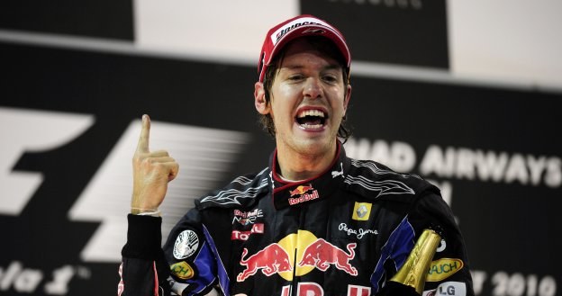 Sebastian Vettel w triumfalnym geście na podium w Abu Zabi /AFP