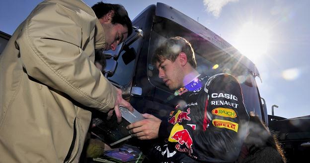 Sebastian Vettel (z prawej) rozdaje autografy /AFP