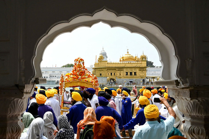 Sikhowie niosą Guru Granth Sahib (świętą księgę Sikhów) w złotym palankinie podczas religijnej procesji w przeddzień rocznicy urodzin dziewiątego sikhijskiego Guru Teg Bahadura w Złotej Świątyni w Amritsar 10 kwietnia 2023 roku. (Foto Narinder NANU / AFP)