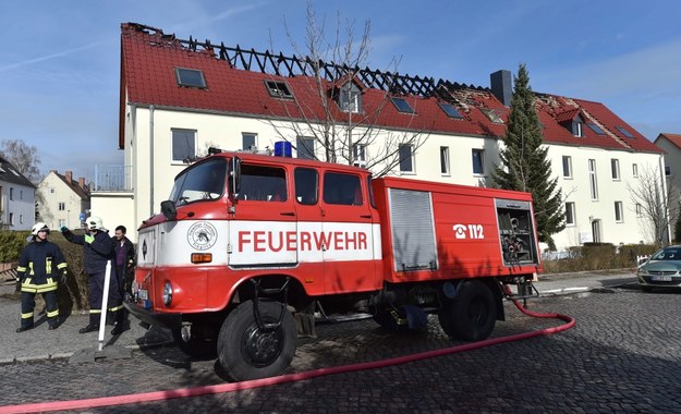 Służby przed budynkiem ośrodka dla uchodźców w Troeglitz /Hendrik Schmidt /PAP/EPA