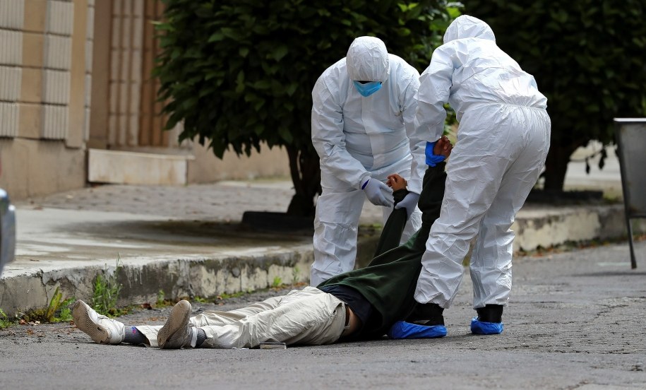 Służby w Quito podnoszą człowieka leżącego na drodze /JOSE JACOME /PAP/EPA