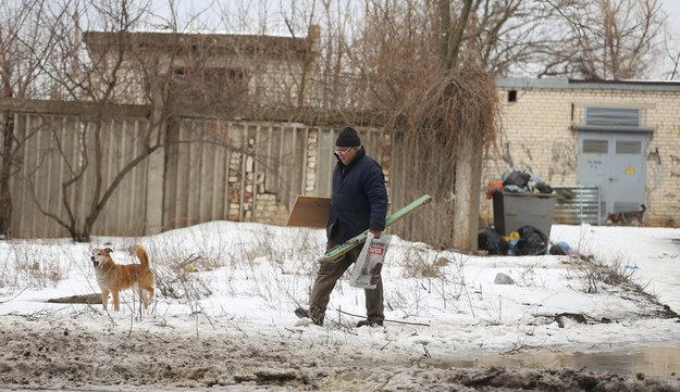Starszy mężczyzna spacerujący z psem w Wuhłedarze w obwodzie donieckim na zdjęciu z 19 lutego br. /AA/ABACA /PAP/Abaca