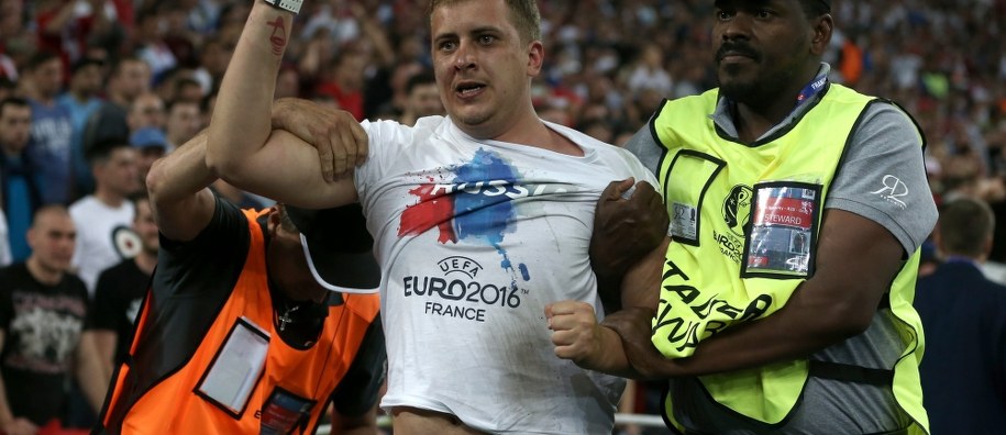 Stewardzi wyprowadzają rosyjskiego pseudokibica ze stadionu w Marsylii /TOLGA BOZOGLU /PAP/EPA