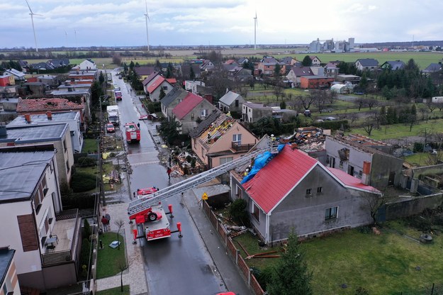 Strażacy i mieszkańcy zabezpieczają zniszczone dachy budynków po przejściu trąby powietrznej w miejscowości Dobrzyca /	Tomasz Wojtasik /PAP