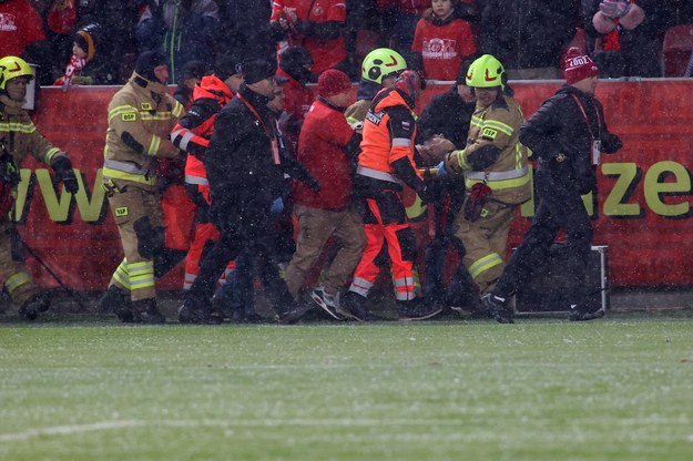Strażacy i służby ratunkowe przewożą kibica do karetki podczas meczu w Łodzi /Marian Zubrzycki /PAP