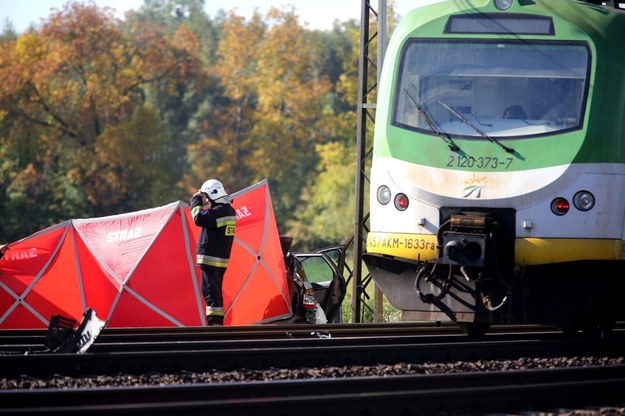 Strażacy pracują na miejscu zderzenia samochodu osobowego z dwoma pociągami na strzeżonym przejeździe kolejowym w Kozerkach koło Grodziska Mazowieckiego (zdjęcie archiwalne) /Tomasz Gzell /PAP