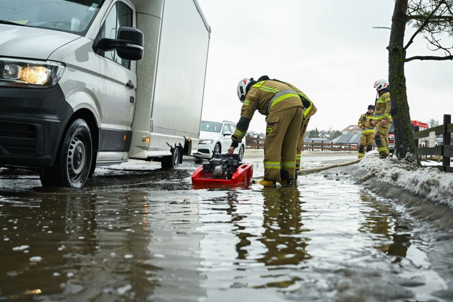 Strażacy przepompowują wodę z roztopów na drodze lokalnej w Otominie k. Gdańska / PAP/Adam Warżawa /PAP