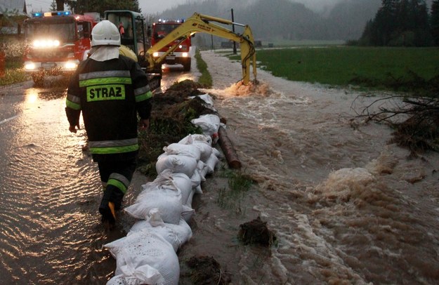 Strażacy układają worki z piaskiem, zabezpieczając zalaną drogę w rejonie Witowa /Grzegorz Momot /PAP