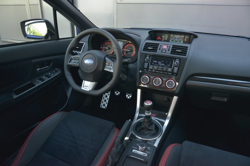 Subaru WRX STI ST000: w stosunku do modelu starszej generacji, w górnej części deski rozdzielczej pojawiło się miękkie tworzywo. Na konsoli środkowej króluje imitacja włókna węglowego. Obsługa jest łatwa. /Motor
