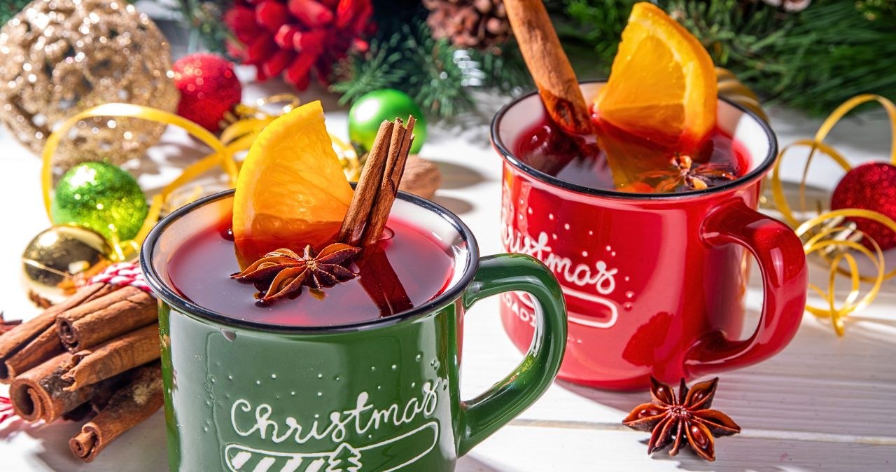 Świąteczny poncz bez alkoholu w kubkach, z pomarańczą, cynamonem i anyżem – ciepły napój dla gości na Boże Narodzenie. /CanvaPro /INTERIA.PL