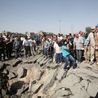 Mieszkańcy Damaszku oglądają lej po wybuchu bomby