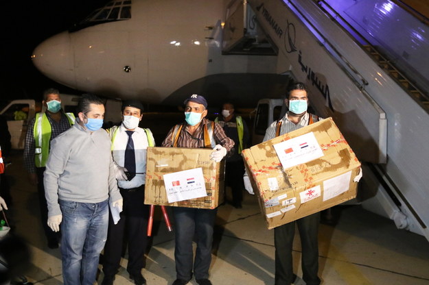 Syryjscy pracownicy rozładowują zapasy medyczne z Chin na międzynarodowym lotnisku w Damaszku /YOUSSEF BADAWI /PAP/EPA