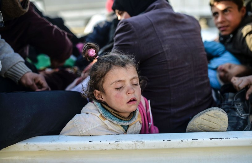 Syryjska dziewczynka, mieszkanka Aleppo, śpi na przejściu granicznym między Syrią a Turcją /AFP