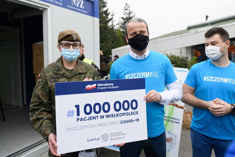 Szeregowa Katarzyna Cyprych (L) oraz wojewoda wielkopolski Michał Zieliński (C) w punkcie szczepień masowych na poznańskiej Malcie, 1 bm. Szeregowa została tym samym milionową pacjentką zaszczepioną w Wielkopolsce /Jakub Kaczmarczyk /PAP