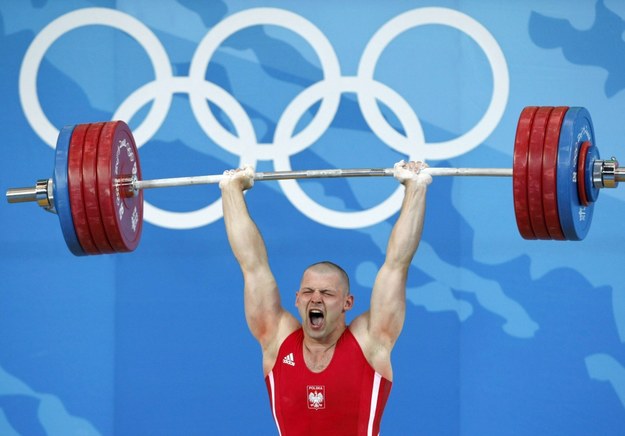 Szymon Kołecki trzyma nad głową sztangę w podrzucie podczas rywalizacji w podnoszeniu ciężarów w kategorii do 94 kg na igrzyskach olimpijskich w Pekinie, 17 sierpnia 2008 /RUNGROJ YONGRIT /PAP/EPA